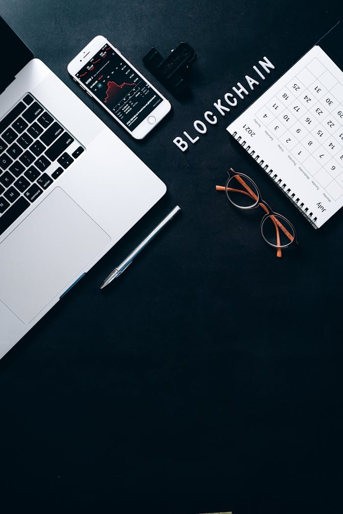 Stylish workspace featuring blockchain concept with a laptop and smartphone on a dark background.